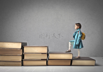 一個背著書包的孩子正走在書籍的階梯上